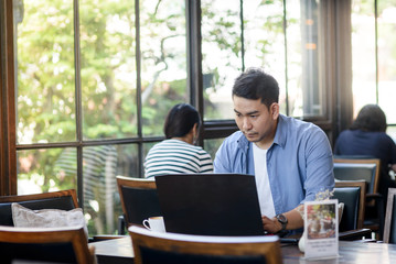 Asian man working with laptop in cafe, work concept.