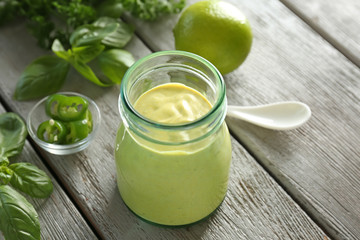 Tasty creamy lime mustard sauce for fish taco in glass jar on kitchen table