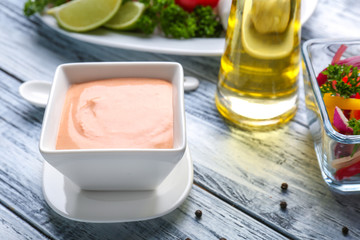 Tasty creamy sauce for fish taco in bowl on wooden table