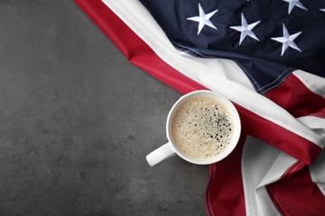 Cup of coffee and American flag on grey background