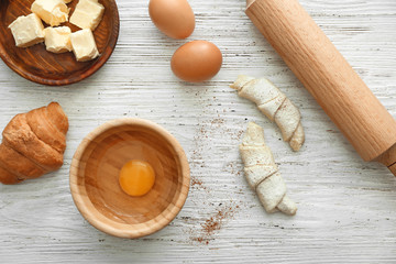 Tasty croissants and products on table