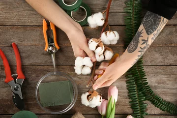 Crédence de cuisine en verre imprimé Fleuriste Fleuriste femme faisant beau bouquet sur fond de bois