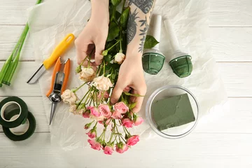 Crédence de cuisine en verre imprimé Fleuriste Female florist making beautiful bouquet on wooden background