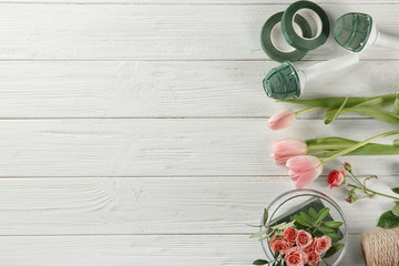 Florist equipment with flowers on wooden background