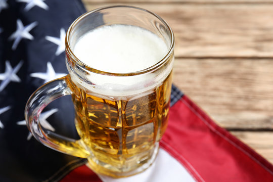 Glass of beer and American flag on table - Powered by Adobe