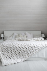 White nordic bedroom interior with knit plaid