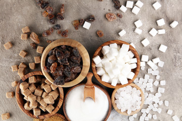 Various types of sugar, brown sugar and white on table