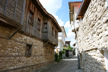 Fototapeta na wymiar A street with traditional Bulgarian wooden houses in the old Nessebar.