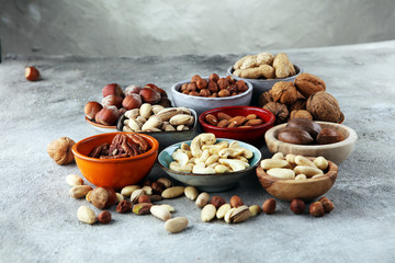 mixed nuts on grey background. Healthy food and snack. Walnut, pecan, almonds, hazelnuts and cashews.