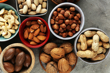 mixed nuts on grey background. Healthy food and snack. Walnut, pecan, almonds, hazelnuts and cashews.