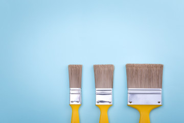 Two brushes for painting on blue colored paper texture