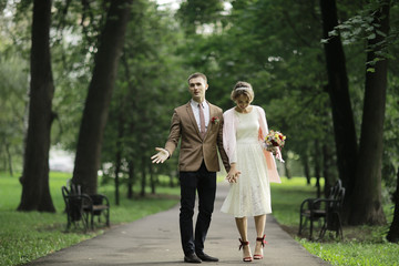 Fototapeta premium Newlyweds groom and bride walking in autumn park