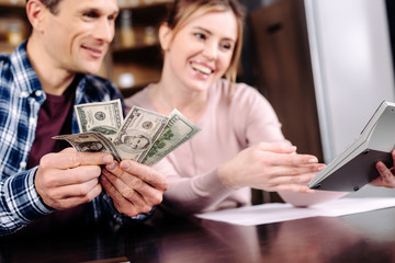 portrait of happy couple counting money together at home
