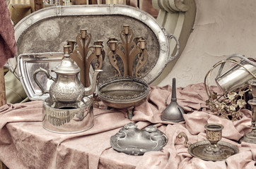 Brass containers and plates, candle holders  and other old vintage copper cookware in the flea...