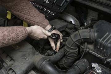 the car mechanic fixes the car engine by tools