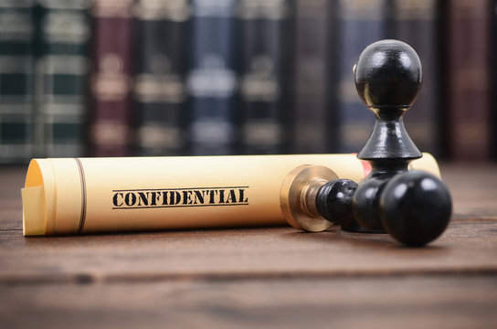 Confidential type of document and notary seals on the wooden background.