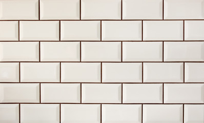 White metro tiles patterned wall. Beige ceramic brick tiles background.