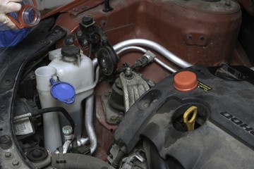 the car mechanic fixes the car engine by tools