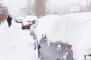 Cars completely covered with snow on parking.