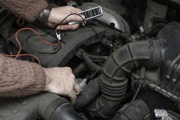 the car mechanic fixes the car engine by tools