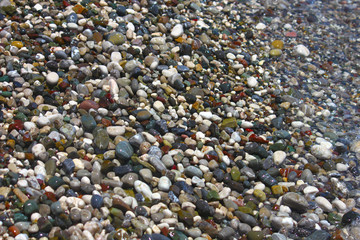 Bright multicolored pebbles on beach in Mediterranean Sea.