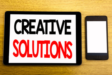 Writing text showing Creative Solutions. Business concept for Brainstorm Thinking Written on tablet laptop, wooden background with sticky note, coffee and pen
