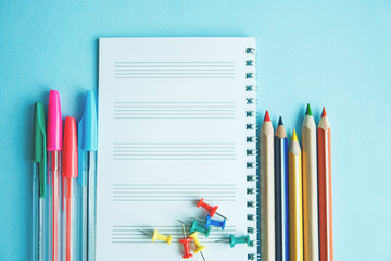 Different school or office supplies on a blue background. Education or business concept. Empty place for text.