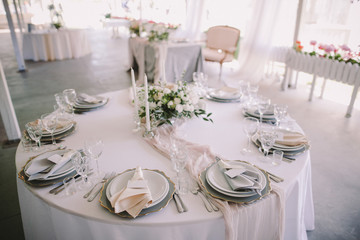 beautiful served table with cutlery, flowers and candles at wedding reception