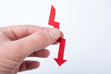 Red arrow in hand, as a symbol of financial fall.