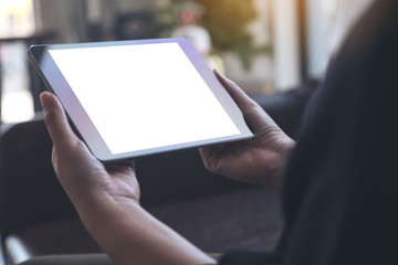 Mockup image of hands holding black tablet with blank white desktop screen