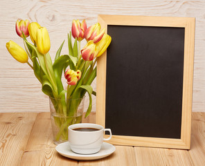Blank board, flowers and cup of coffee.
