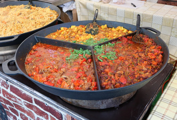 Fast street food - stewed haricot, paprika, tomato sauce  and potato with boiled beef in big frying pan.