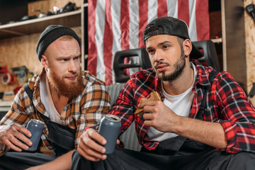 handsome mechanics having lunch together at garage