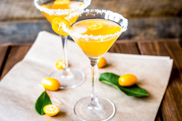 cocktail with kumquat on wooden background