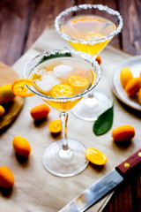cocktail with kumquat on wooden background