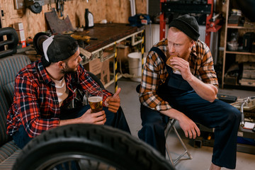 Fototapeta na wymiar mechanics drinking beer and having lunch at garage