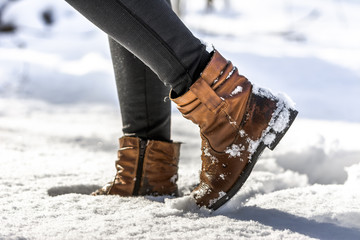 Women's boots in snow, brown shoes for winter