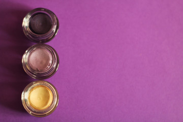 Set of liquid eye shadows, violet background, free copy space