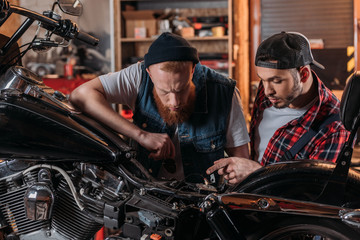 repair worker talking to customer and showing problem in motorcycle