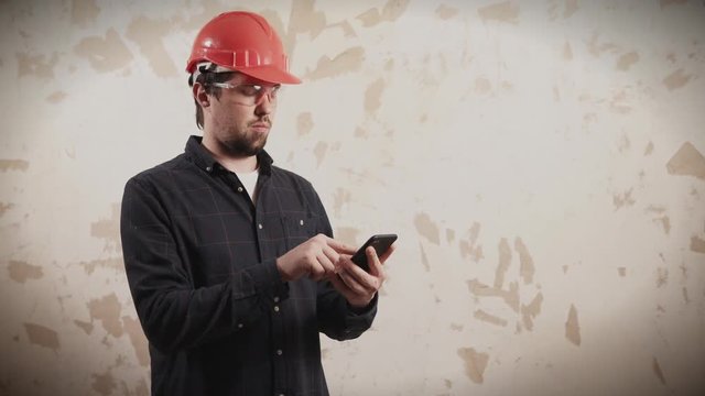 Brigadier of builders is inspecting and estimating planned works. He is using calculator application in his mobile