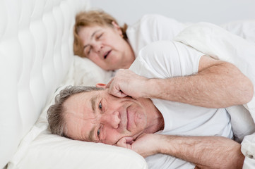 Fototapeta na wymiar Portrait of senior man who can not sleep because his wife snores