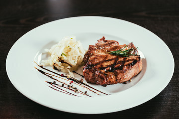 delicious grilled juicy steak with rosemary and sauce on plate
