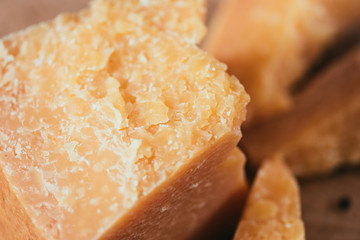 close-up view of delicious parmesan cheese on wooden cutting board