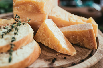 close-up view of delicious parmesan cheese and slices of fresh baguette on wooden cutting board