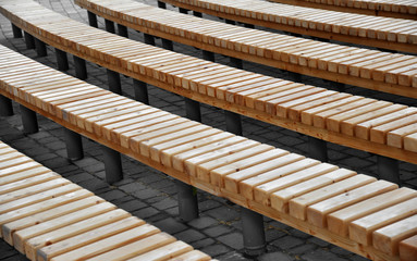 Obraz na płótnie Canvas Wooden benches without backrest on the street as background