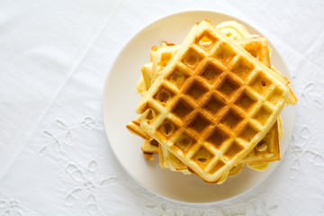 Healthy breakfast. Belgian waffles with butter, blueberry and nuts on white tablecloth. Selective focus