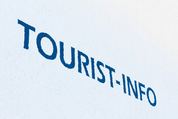 "Tourist information" sign on white wall
