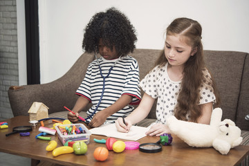 Naklejka premium Child playing toy and drawing picture together in the living room.