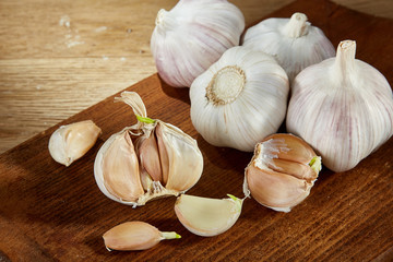 Garlic close up on wooden plate on rustic background, shallow depth of field, selective focus, macro.