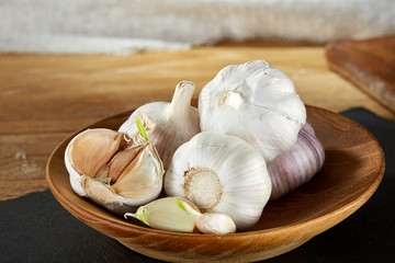 Garlic composition close up on black flat piece of board, macro, shallow depth of field, selective focus.